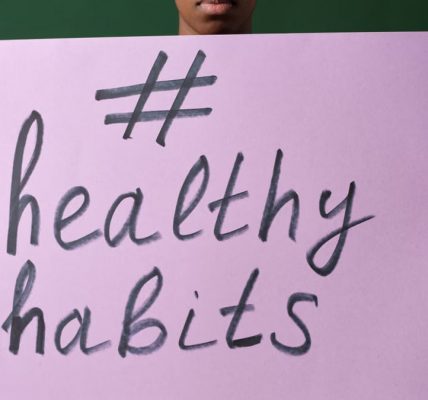 Person holding a "#healthyhabits" sign, emphasizing wellness.